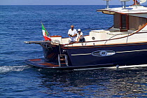 Couple fishing from the stern of an Abati Yachts' Portland 55ft, called a "lobster" boat because it is copied from the original american lobster fishing boats. Tuscany, Italy.