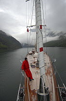 180ft Superyacht "Adele" exploring the Norwegian Fjords in the Sognefjord area, during week 25 of her maiden voyage. A member of the crew is admiring the view on deck. ^^^ Adele is a 180-foot Andre H...