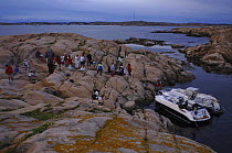 Crew and guests of superyacht "Adele" enjoy some time on land on Sweden's rocky coast, during the yacht's maiden voyage in 2005.
