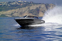 Power boat cruising along the coast. Motorboat "One", Cantieri di Baia, off the coast of Baia, Naples, Italy.