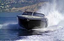 Power boat cruising along the coast. Motorboat "One", Cantieri di Baia, off the coast of Baia, Naples, Italy.