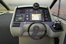 Controls and steering wheel on a power boat. Motorboat "One", Cantieri di Baia, off the coast of Baia, Naples, Italy.