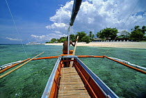 Man on the bow of his Banca, a typical fishing boat in the Philippines, near the coast of Balicasag Island (Bohol), Philippines.