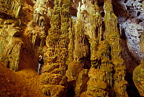 Speleologist looking large stalagmites in Green Cave (Grotta Verde), Capo Caccia, Sardinia.