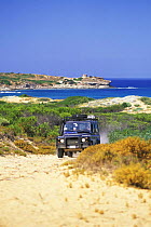 Four-wheel drive jeep on dirt road at Torre del Porticciolo, Sardinia.
