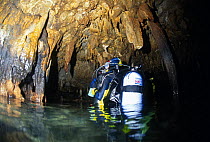 A scuba diver examining rock formations in Grotta del Presepe (The Cave of the Nativity / Crib Cave) in the dive centre of Marina di Camerota, Campania, Italy.