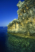 The sheer rock can be seen plunging below the clear water on the Italian Mediterranean coast, Marina di Camerota, Campania, Italy.