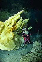 Scuba diver examining Alabaster Cave (La Grotta dell'Alabastro), Marina di Camerota, Campania, Italy.