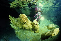 A scuba diver examining pure alabaster mineral in the Alabaster Cave (La Grotta dell'Alabastro) in the dive centre of Marina di Camerota, Campania, Italy.