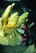Scuba diver examining pure alabaster mineral, Alabaster Cave (La Grotta dell'Alabastro), Marina di Camerota, Campania, Italy.