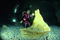 Scuba diver examining pure alabaster mineral in Alabaster Cave (La Grotta dell'Alabastro), Marina di Camerota, Campania, Italy.