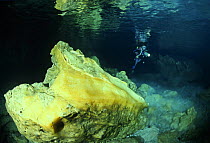 A scuba diver examining pure alabaster mineral in the Alabaster Cave (La Grotta dell'Alabastro) in the dive centre of Marina di Camerota, Campania, Italy.