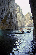 A kayaker paddling through the "grottoni" caves off the coast of Ponza Island, Italy.