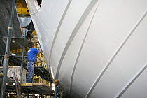 Fitters at work at the Cantieri Alfamarine boatyard, Fiumicino area of Lazio, Italy. Here a man works on the hull of an Alfamarine 78'.
