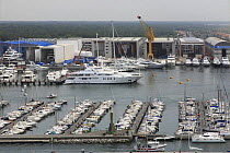 Yachts moored in the marina in Viareggio, dwarfed by the superyachts behind, Tuscany, Italy.