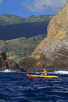 Kayaker exploring Moku Ho'oniki Islet off Molokai, Hawaii.