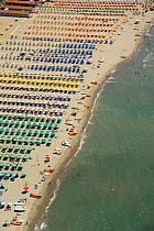 Rows of colourful umbrellas and sunbeds lining the beach resort of Viareggio, Tuscany, Italy. Tyrrhenian Sea, Mediterranean.