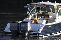 A couple relaxing on an anchored Pursuit powerboat in Annapolis, Maryland, USA.