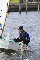 Girl sailing optimist.