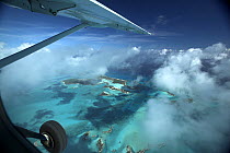 Aerial view with aeroplane wings and clouds, of Exuma, part of the chain of 365 islands that form the Bahamas.
