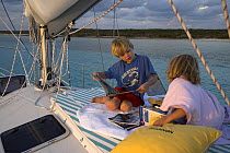 Children reading on the deck of the Shannon Shoalsailor, Exuma, Bahamas. ^^^This innovative, keelless, shallow draft beachboat is designed to roam shallow waters.