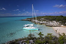 Shannon Shoalsailor moored alongside a sandy beach. This innovative beachboat is a shallow draft boat designed to roam shallow waters such as these in Exuma, the Bahamas.