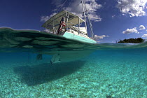 Split-level shot of the hull of the Shannon Shoalsailor illustrating how this innovative, keelless, shallow draft beachboat is designed to roam shallow waters such as these in Exuma, the Bahamas.