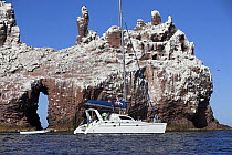 Catamaran cruising past a natural archway in the rock, Los Islotes, Mexico.