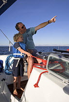 Father pointing something out to his son while on board a catamaran cruising to Isla San Francisco, Mexico. Model released.