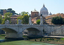 The Vittorio Emanuele Bridge spanning the river Tiber (Tevere) with the dome of Saint Peter's church towering in the background, Rome, Italy. ^^^Saint Peter's Basilica is perhaps the largest church in...