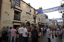 Cowes High Street during Skandia Cowes Week. People walk past the Anchor Inn.