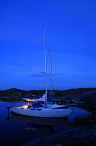 Night time anchorage of Smogholmarna between Lyr and Tjorn, Sweden, two boats tied up alongside each other in a granite rock natural harbour.