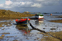 Two wooden boats on the riverbed in the morning, at low tide near Paimpol, Brittany, France.