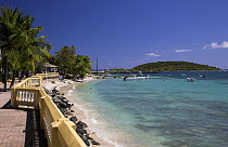 A brick boardwalk lines the beach in the small town of Esperanza with boats moored in the harbour, Vieques, Puerto Rico.