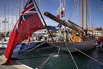 A large flag flying from the stern of a wooden classic boat preparing for the St Barths Bucket Regatta, St Barthelemy, Caribbean.