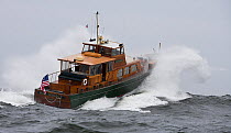 Classic powerboat "Pearl Necklace" crashing through rough swell in Newport, Rhode Island, USA.