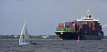 A sailboat getting out of the channel for a container ship, Charleston Harbour, South Carolina, USA.