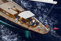 140ft luxury schooner "Skylge", designed by André Hoek and built by Holland Jachtbouw, with a man at the helm, sailing in the French Riviera, France. Property released.