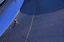 A crew member of ^Maximus^ going up the rigging to check out the sails during the 2006 Newport to Bermuda Race. Model and Property Released.