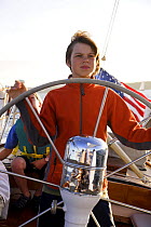 Boy steering the 12m yacht "Weatherly" in Newport, Rhode Island, USA.