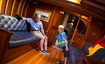 Man and young boy inside the 12m yacht "Weatherly" in Newport, Rhode Island, USA.