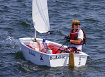 Young boy sailing an Optimist, Rhode Island, USA.