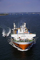 Yacht transport ship leaving port, accompanied by a pilot vessel, Newport, Rhode Island, USA.