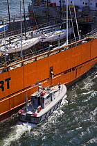 Yacht transport ship leaving port, accompanied by pilot vessel. Newport, Rhode Island.