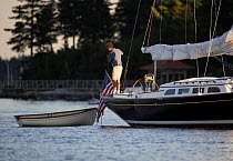 Man tying a tender to the stern of a Morris 42 cruising yacht, Maine