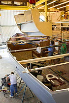 Wooden boat-part being winched into place for interior construction of a yacht.