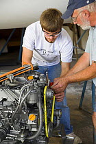 Two men building a marine engine during the construction of a yacht.