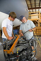 Two men building a marine engine during the construction of a yacht.