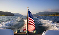 Motorboat at speed, with the American flag flying from the stern.