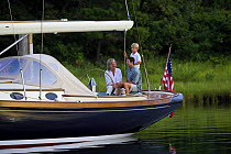 Family on the stern of a Friendship 40 cruising yacht, Rhode Island. Model and property released.